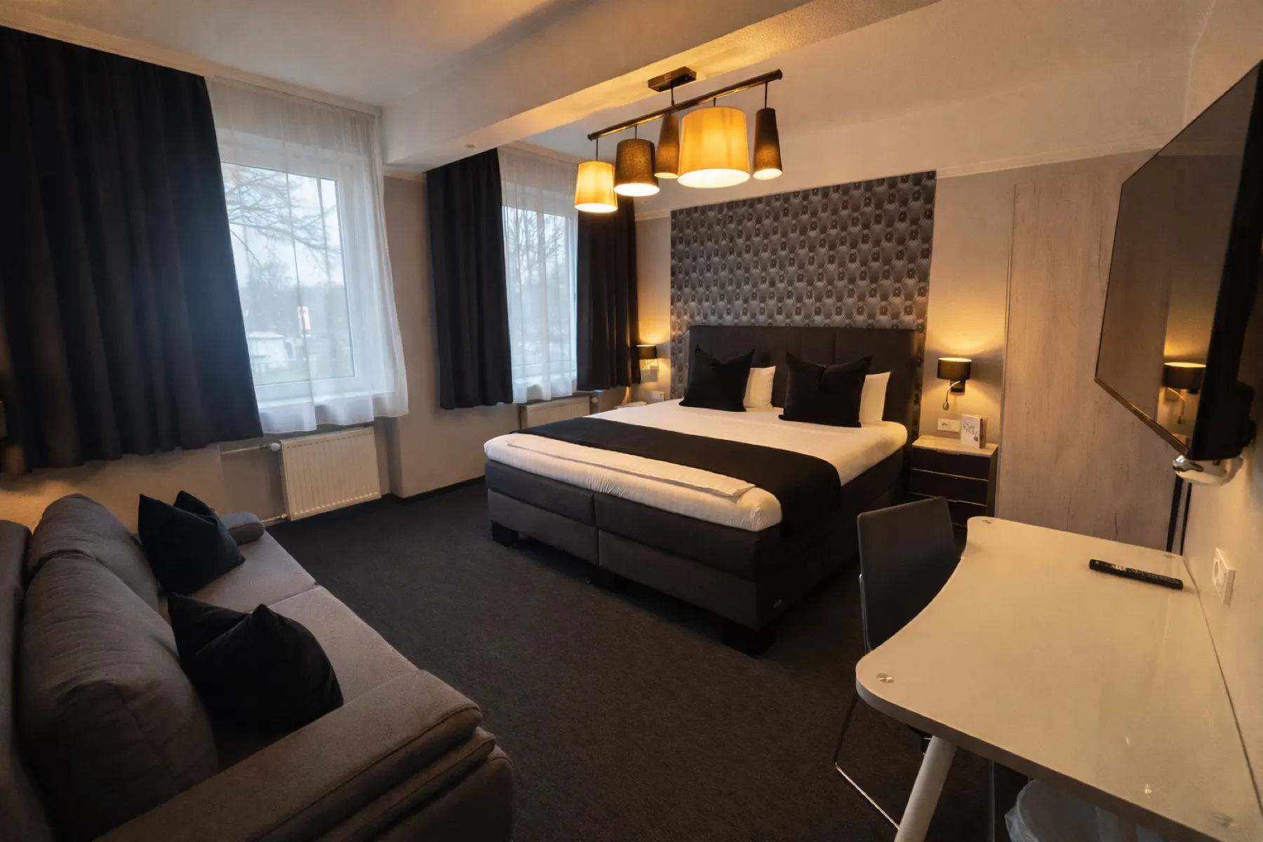 Doppelzimmer mit großem Bett, Sofa und Schreibtisch